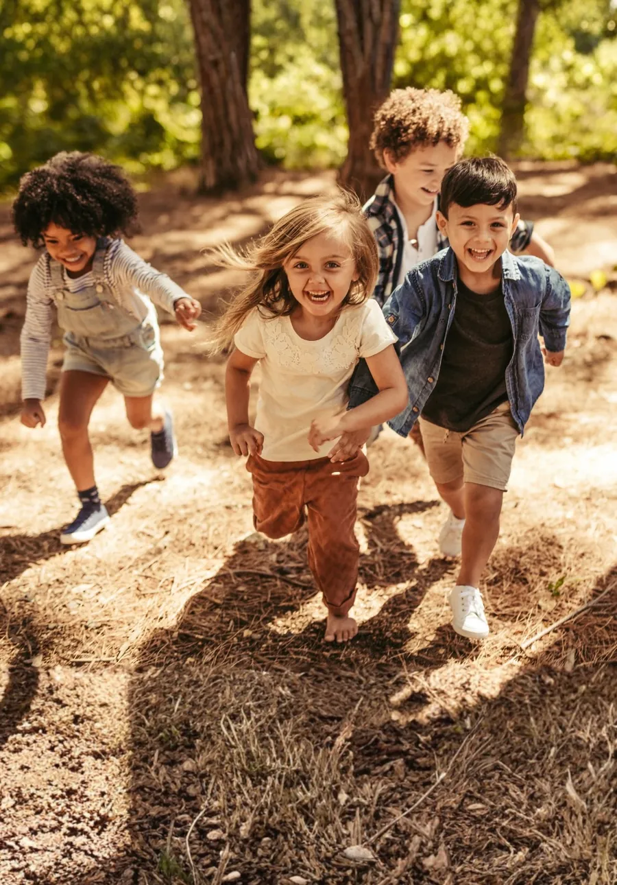 Children running together through a wood.